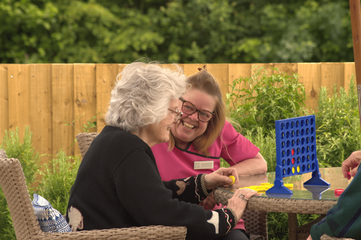 Care staff engaging in conversation with elderly residents at Elliscombe House care home in Somerset